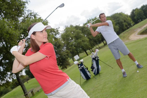 Para praktykuje golf swing — Zdjęcie stockowe