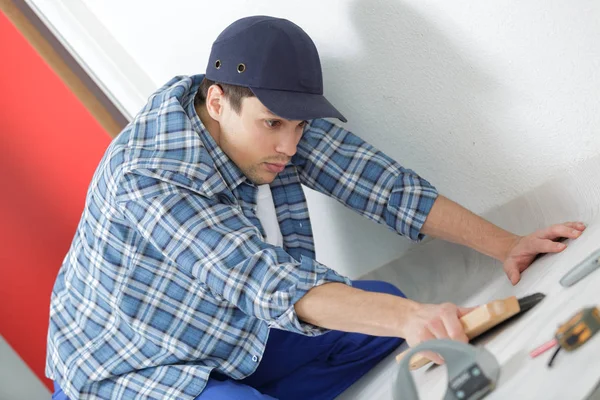 Joven técnico instalando piso en la obra — Foto de Stock