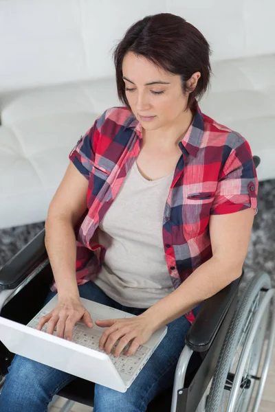 ラップトップに入力する車椅子の女性 — ストック写真