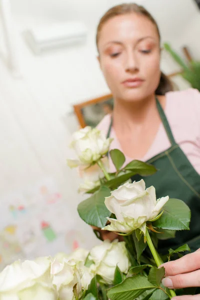 Florista cuidadosamente organizar flores — Fotografia de Stock