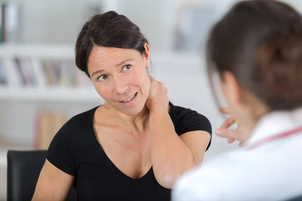 Paciente mujer consultando al médico para problemas de dolor de espalda —  Fotos de Stock