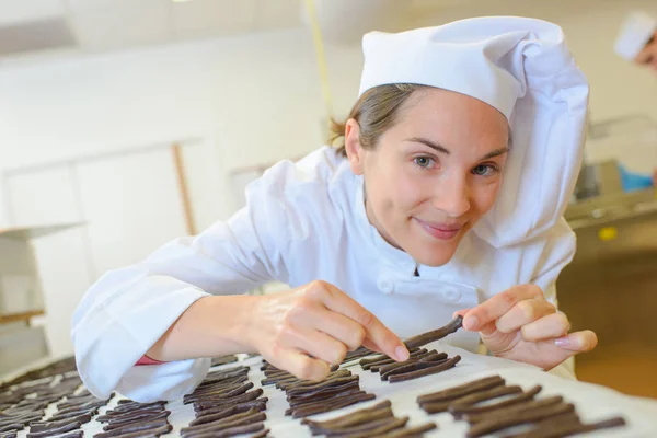 Chef organizando paus de chocolate — Fotografia de Stock