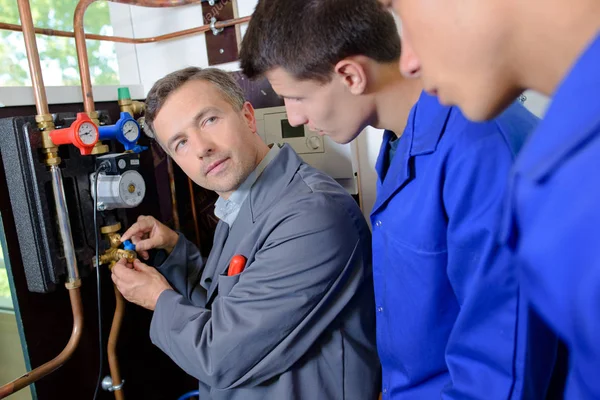 Tradesman training two apprentices — Stock Photo, Image