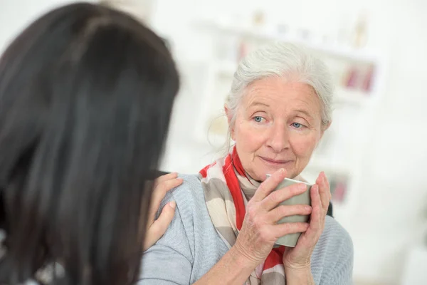 Läkare talar till en äldre patient — Stockfoto