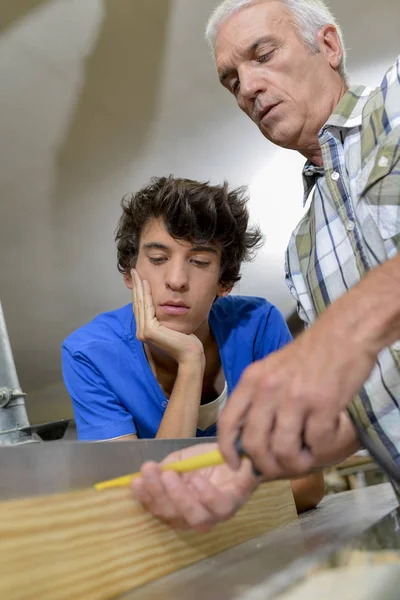 Carpinteiro ensinando seu filho adolescente — Fotografia de Stock