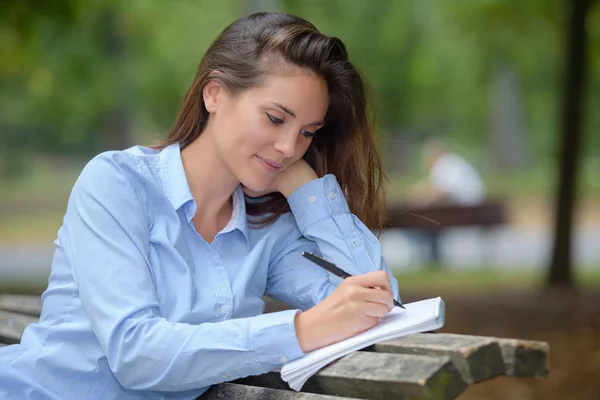 Mujer escribiendo en el parque — Foto de Stock