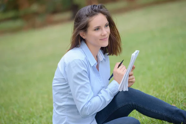 Fille assise dans un parc — Photo