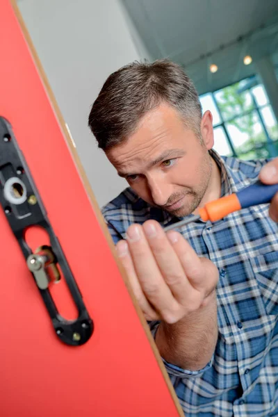 Hombre encajando nueva cerradura a puerta — Foto de Stock