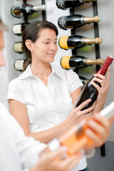 Жінка вибирає пляшку вина — стокове фото