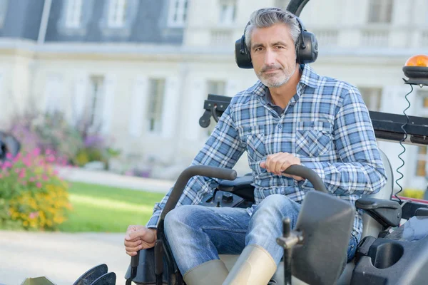 Man kör gräsklipparen och man — Stockfoto