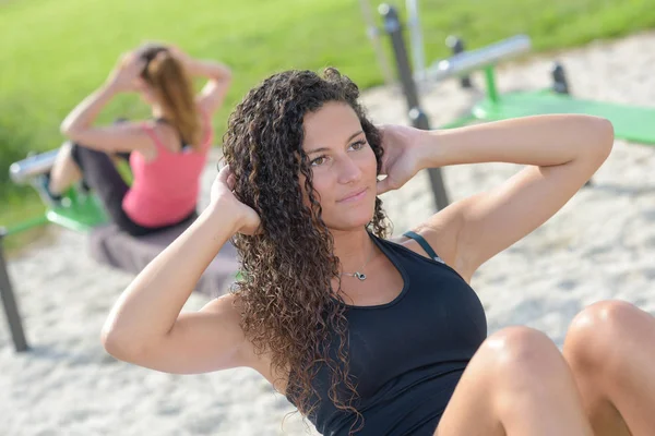 Vrouwen doen van buikspieroefeningen in park — Stockfoto