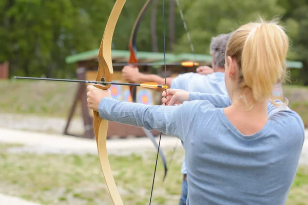 Femme et homme pratiquant le tir à l'arc — Photo