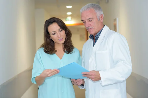 Travailleurs médicaux en discussion dans le couloir hospitalier — Photo