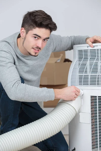 Jóképű fiatalember villanyszerelő telepítése légkondicionáló ügyfél házban — Stock Fotó