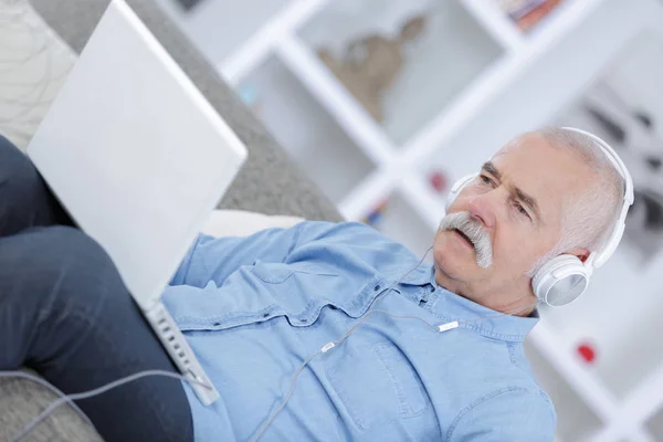 Senior man listening to music with headphones — Stock Photo, Image