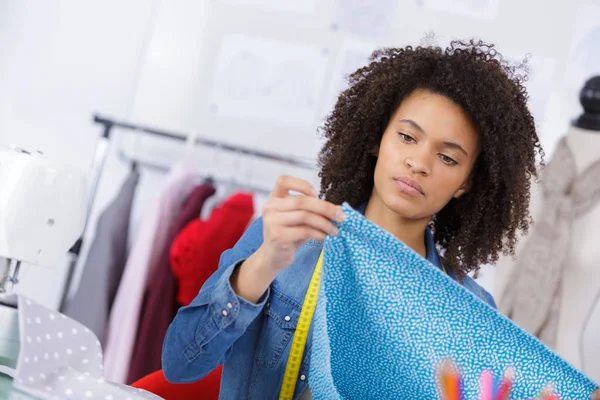 Attractive seamstress measuring a length of fabric — Stock Photo, Image