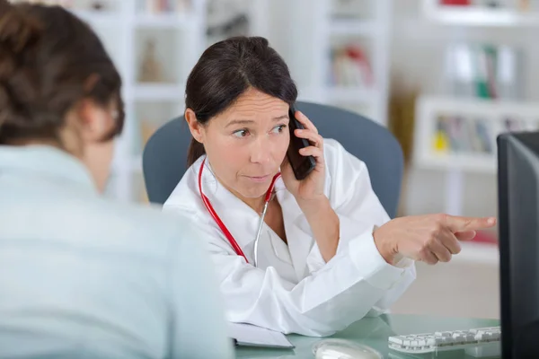 Médecin avec patient parlant au téléphone et montrant les résultats — Photo