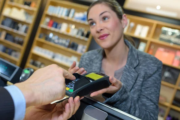 Cliente haciendo el pago a través de smartwatch en la tienda de perfumes — Foto de Stock
