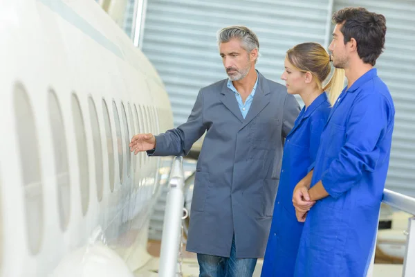 Man showing aircraft fuselage to students — Stock Photo, Image