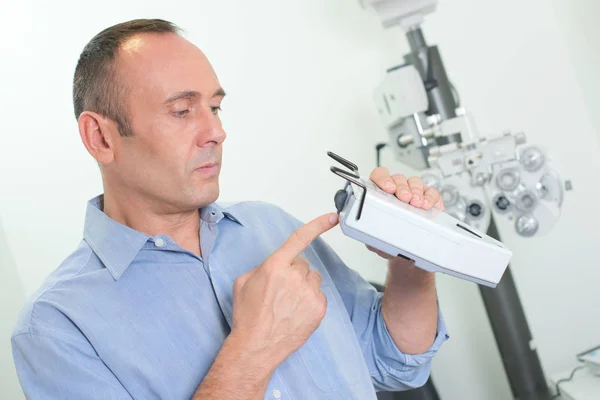 Optician checking equipment and optician — Stock Photo, Image