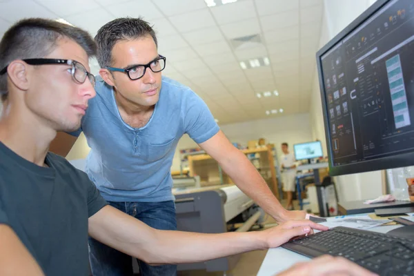 Dois homens usando óculos olhando para a tela do computador — Fotografia de Stock