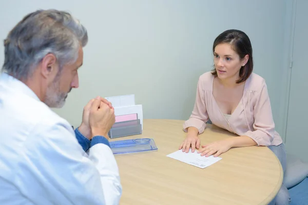 Concerned female patient talking to doctor — Stock Photo, Image