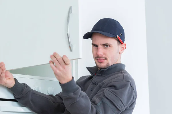 Homem porta do armário de montagem na cozinha — Fotografia de Stock