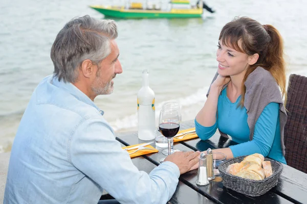 Casal tendo refeição ao lado do lago — Fotografia de Stock
