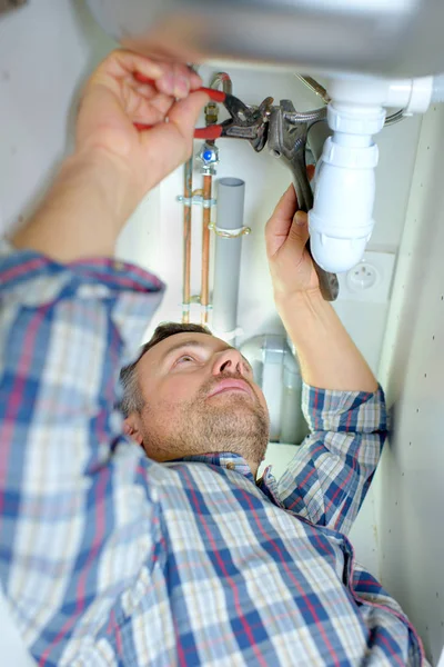 Loodgieter werken onder sink — Stockfoto