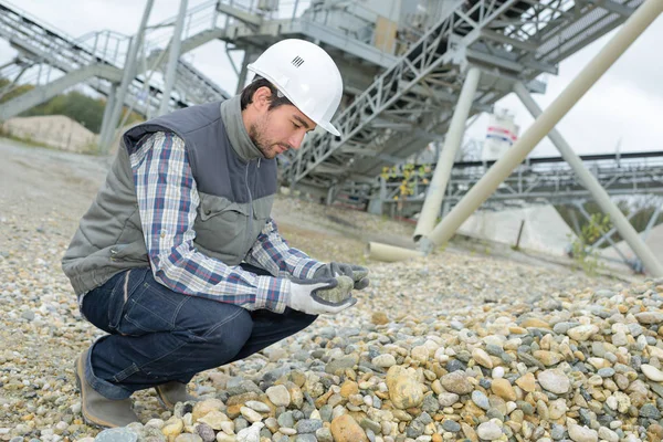 Homem que examina pedras na pedreira — Fotografia de Stock