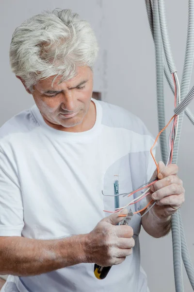 Eletricista usando um par de alicates — Fotografia de Stock