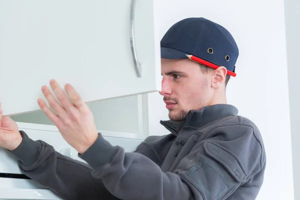 Handwerker repariert den Schrank in der Küche — Stockfoto