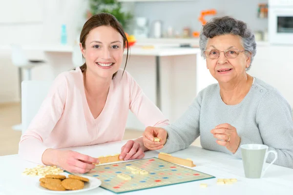 Oudere vrouw spelen van een bordspel — Stockfoto
