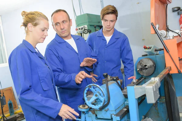 Tutor instruyendo a los aprendices sobre maquinaria —  Fotos de Stock