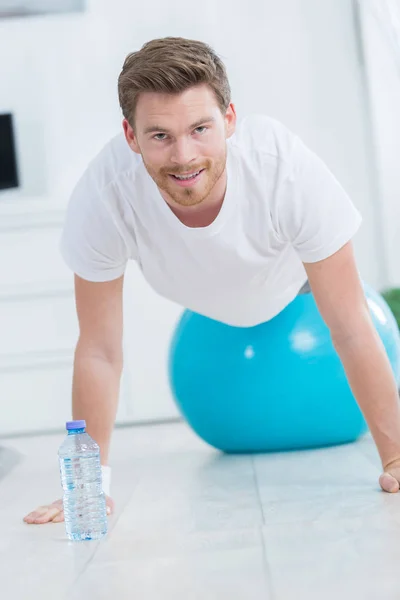 Sportieve man doet push ups oefeningen op de bal van de sportschool — Stockfoto