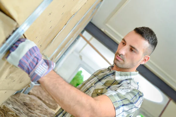 Man fitting insulation into wall — Stock Photo, Image
