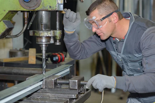 Işçi ile büyük bir matkap bir atölyede metal delme — Stok fotoğraf