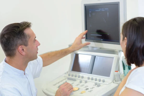 Médico mostrando tela de ultra-som para o paciente — Fotografia de Stock