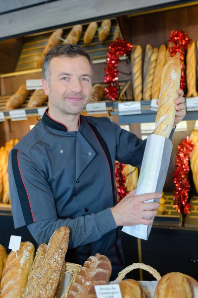 Bäckereifachverkäufer ist stolz auf seine Brotproduktion — Stockfoto