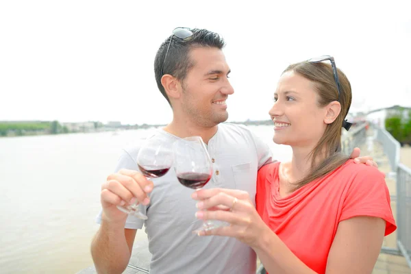 Couple boire du vin par rivière — Photo