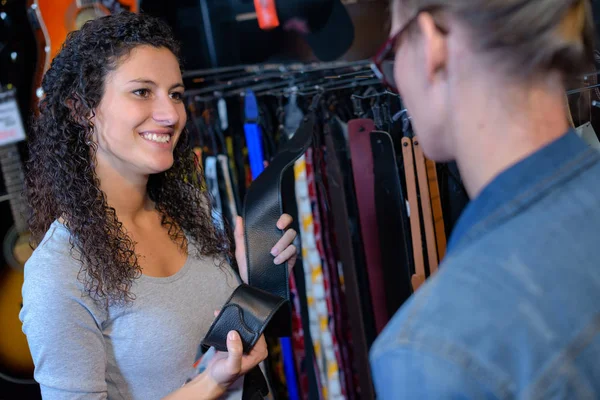 Damen tittar på remmen i musikbutiken — Stockfoto