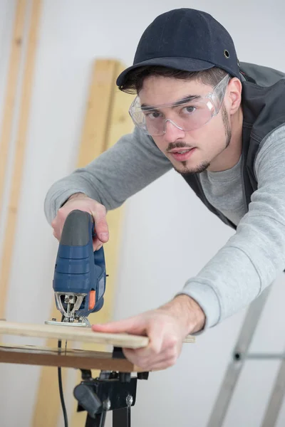 Young man working with wood natural background behind — Stock Photo, Image