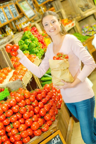 Señora comprando tomotoes y abundancia —  Fotos de Stock