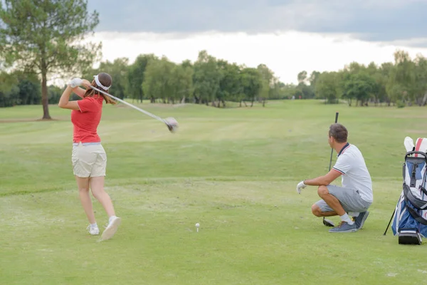 Žena hrát golf, manžel sledoval shot — Stock fotografie