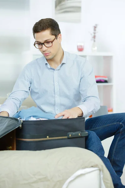 Nahaufnahme eines Geschäftsmannes, der Kleidung in Reisetasche packt — Stockfoto