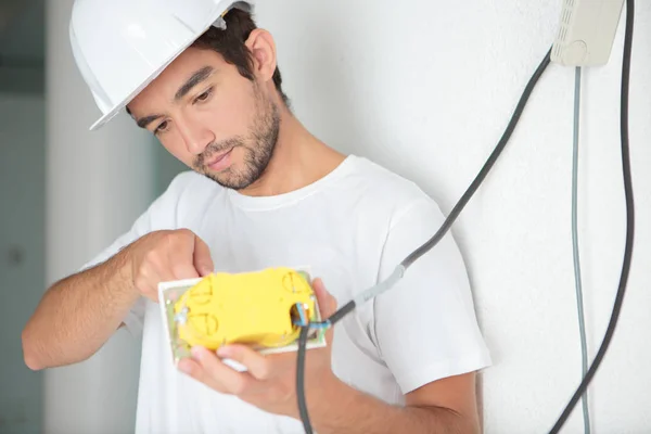 Elecrician en el sitio de trabajo y el sitio de trabajo — Foto de Stock