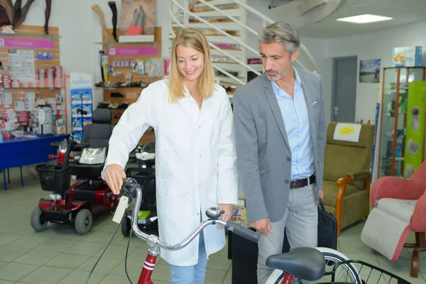 Woman presenting bicycle in store — Stock Photo, Image