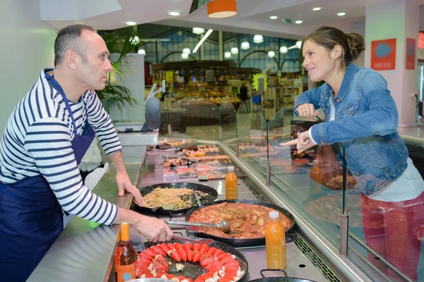 Lady buying food from counter — Stock Photo, Image