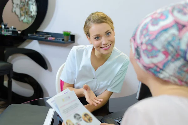Жіночий клієнт в салоні краси з косметологом — стокове фото