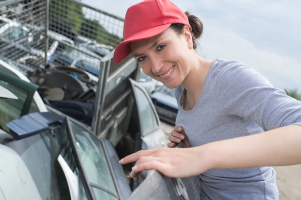 Frau mit Autotür auf Schrottplatz — Stockfoto